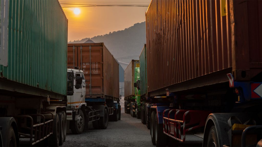 File di camion parcheggiati in un'area di sosta sicura per prevenire furti nel trasporto merci